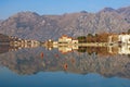 Beautiful symmetrical landscape where mountains and coast are reflected in water. Montenegro, Bay of Kotor, Dobrota town