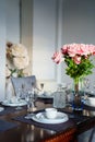 A beautiful table served with dishes and a bouquet of roses.