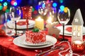 Beautiful table setting for Christmas party or New Year celebration at home. Cozy room with a fireplace and Christmas tree in a ba Royalty Free Stock Photo