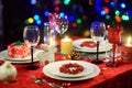 Beautiful table setting for Christmas party or New Year celebration at home. Cozy room with a fireplace and Christmas tree in a ba Royalty Free Stock Photo