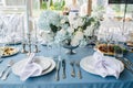 Beautiful table setting for an event on a terrace. Empty plates with napkins