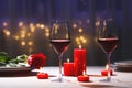Beautiful table setting with glasses of wine  candles and rose against blurred lights. Romantic dinner for Valentine\'s day Royalty Free Stock Photo