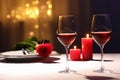 Beautiful table setting with glasses of wine, candles and rose against blurred lights. Romantic dinner for Valentine`s day Royalty Free Stock Photo