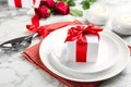 Beautiful table setting for Valentine`s Day dinner with gift box on white marble background Royalty Free Stock Photo