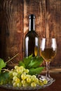 Table white wine in glass and black bottle on desk with grape Royalty Free Stock Photo