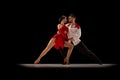 Beautiful, talented, attractive young man and woman, professional dancers performing, dancing tango over black Royalty Free Stock Photo