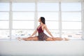 Beautiful talented woman doing the split at window background