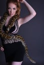 Beautiful, Tall, Slim, Busty Redhead Model in a sexy, black, mesh Dress, posing with a Snake