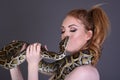 Beautiful, Tall, Slim, Busty Redhead Model in a sexy, black, mesh Dress, posing with a Snake