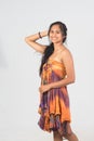 Beautiful tan female model in strapless dress posing on white ba Royalty Free Stock Photo