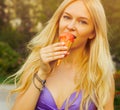 Beautiful tanned blond girl eating ice cream summer hot day. solar flare. Portrait on a street. Outdoor.