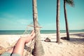 Beautiful Tanned legs of women. relax on hammock at sandy tropical beach Royalty Free Stock Photo