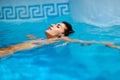 Beautiful tanned woman in bikini relaxing in swimming pool Royalty Free Stock Photo