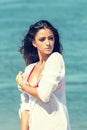 Beautiful tanned woman posing at the sea coast fashion photo. Beach travel. Summer vibes