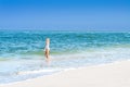 Beautiful tanned woman in swimsuit is walking on the ocean beach Royalty Free Stock Photo