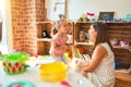 Beautiful teacher and blond student toddler girl playing with dinosaurs at kindergarten Royalty Free Stock Photo