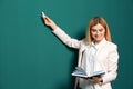 Beautiful teacher with book pointing at chalkboard Royalty Free Stock Photo