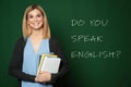 Teacher near green chalkboard with text Do You Speak English Royalty Free Stock Photo