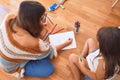 Beautiful teacher and toddler drawing using pencils and paper around lots of toys at kindergarten Royalty Free Stock Photo