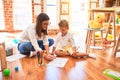 Beautiful teacher and toddler drawing using pencils and paper around lots of toys at kindergarten Royalty Free Stock Photo