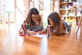 Beautiful teacher and toddler drawing using pencils and paper around lots of toys at kindergarten Royalty Free Stock Photo