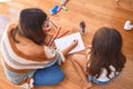 Beautiful teacher and toddler drawing using pencils and paper around lots of toys at kindergarten Royalty Free Stock Photo