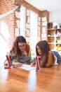 Beautiful teacher and toddler drawing using pencils and paper around lots of toys at kindergarten Royalty Free Stock Photo