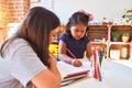 Beautiful teacher and toddler girl drawing draw using colored pencils at kindergarten Royalty Free Stock Photo