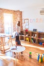 Beautiful teacher and toddler girl drawing draw using colored pencils at kindergarten Royalty Free Stock Photo