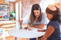 Beautiful teacher and toddler girl drawing draw using colored pencils at kindergarten Royalty Free Stock Photo