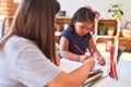 Beautiful teacher and toddler girl drawing draw using colored pencils at kindergarten Royalty Free Stock Photo