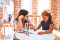 Beautiful teacher and toddler girl drawing draw using colored pencils at kindergarten Royalty Free Stock Photo