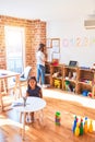 Beautiful teacher and toddler girl drawing draw using colored pencils at kindergarten Royalty Free Stock Photo