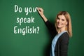 Beautiful teacher writing question DO YOU SPEAK ENGLISH