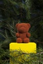 A beautiful teddy bear on a yellow wooden block