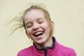 Beautiful teen blonde girl laughs, hair fluttering in the wind Royalty Free Stock Photo