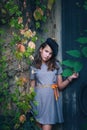 Beautiful teen girl in dress and black beret retro style look outdoor near old metal door and colorful creeper around
