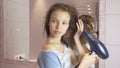 Beautiful teen girl dries hair a hairdryer in bathroom Royalty Free Stock Photo