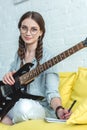 beautiful teen girl with electric guitar writing song Royalty Free Stock Photo