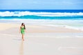 Beautiful teen girl in green dress walking along Hawaiian beach Royalty Free Stock Photo