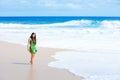 Beautiful teen girl in green dress walking along Hawaiian beach Royalty Free Stock Photo