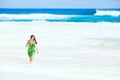 Beautiful teen girl in green dress walking along Hawaiian beach Royalty Free Stock Photo