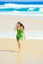 Beautiful teen girl in green dress walking along Hawaiian beach Royalty Free Stock Photo