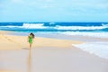 Beautiful teen girl in green dress walking along Hawaiian beach Royalty Free Stock Photo