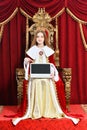 Beautiful teen girl holding laptop while sitting in vintage armchair Royalty Free Stock Photo