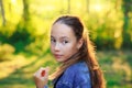 Beautiful Teen Girl is looking at the camera and smiling at the park in sunset Royalty Free Stock Photo