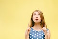 Teen girl on yellow background shows thumbs up