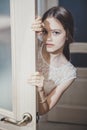 Beautiful teen girl peeping from behind the door Royalty Free Stock Photo