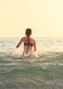 Beautiful Teen Girl playing In Sea Waves. Jump Accompanied By Water Splashes. Summer  Day, Happy childhood, Ocean Coast concept Royalty Free Stock Photo