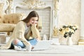 Beautiful teen girl sitting on floor and using laptop Royalty Free Stock Photo